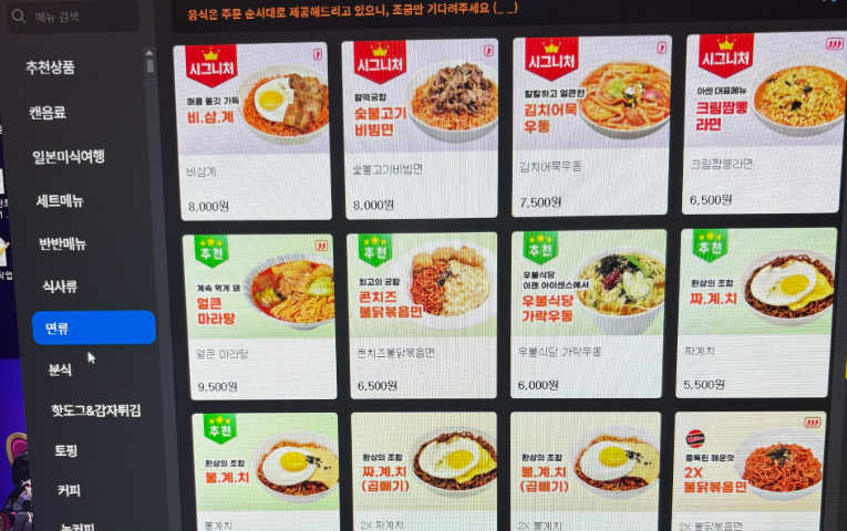 Korean PC bang food-ordering screen showing Assorted rice dishes, tteokbokki, snacks, and drinks served at a Korean PC bang