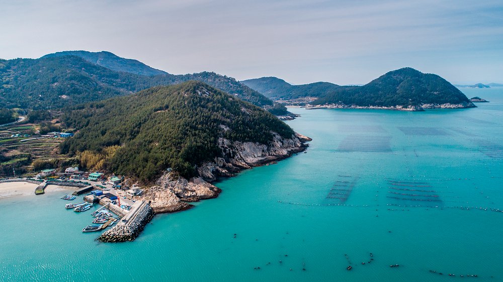 Aerial view of fishing boats, breakwaters, and aquaculture farms off Wando